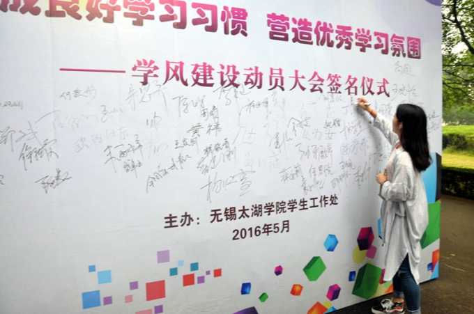 9学生在学风建设动员大会签名墙上签名.jpg